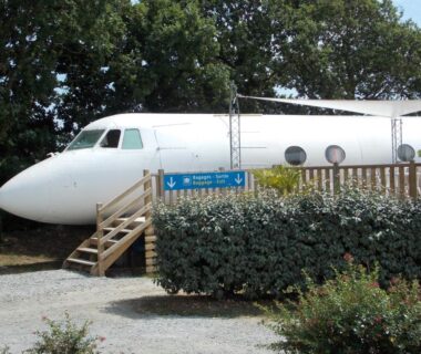 Fuselage d'avion aménagé dans la végétation au Camping Insolite Le Haut Village