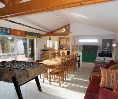 Salle commune avec baby-foot grande table et canapés au Camping Insolite Le Haut Village