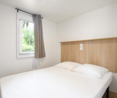 Chambre avec lit double et fenêtre au Camping International