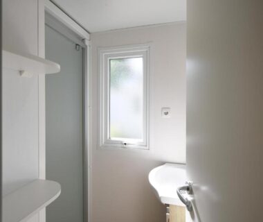 Salle d'eau compacte avec douche et lavabo au Camping International