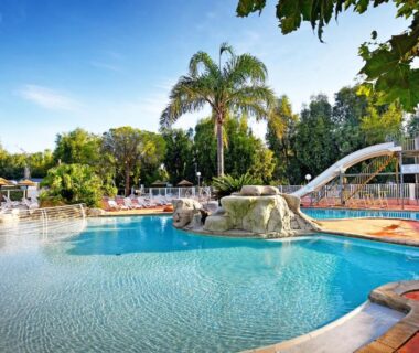 Piscine extérieure avec toboggan et transats au Camping International