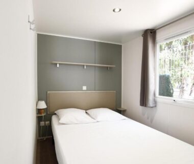 Chambre double lumineuse avec fenêtre donnant sur la verdure au Camping International