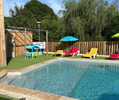Piscine extérieure avec transats et parasols au Camping L Eden Road