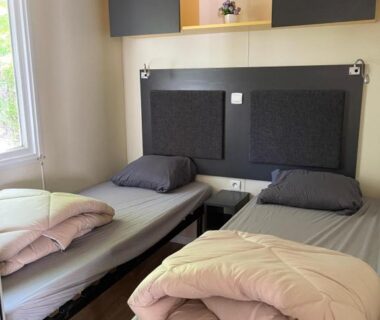Chambre avec deux lits simples et fenêtre dans le Camping L Eden Road