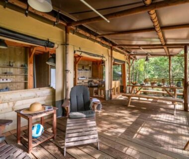 Terrasse en bois avec fauteuils et table à manger au Camping LA SERRE