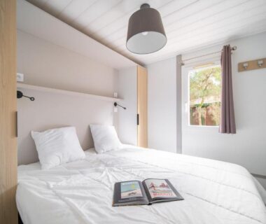 Chambre avec lit double et fenêtre dans le mobil-home du Camping LANDAE