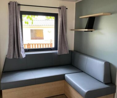 Coin salon près de la fenêtre dans l'hébergement du Camping LE MOULIN DE CAUDON