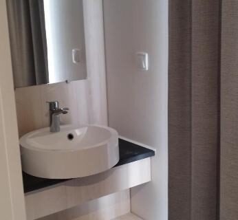 Dans le mobil home lavabo rond et étagères du Camping LES DUNES Mobil home 6 personnes