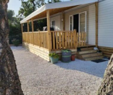 Allée gravillonnée et terrasse en bois du mobil-home Camping L'ILE D'OR