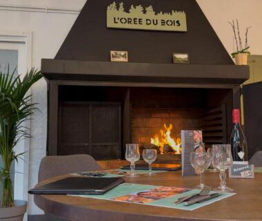 Intérieur avec cheminée et table dressée dans le camping L'Orée du Bois