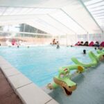 Piscine couverte avec bouées et transats au Camping La Belle Etoile