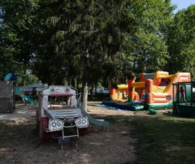 Aire de jeux avec château gonflable et voiturette au Camping La Belle Etoile