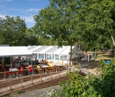 Terrasse couverte avec tables et chaises au Camping La Belle Etoile