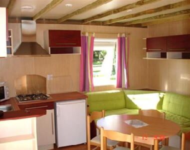 Intérieur avec kitchenette et coin salon du Camping La Clé des Champs