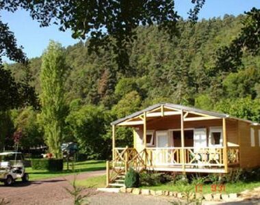 Emplacement herbeux avec chalet en bois et terrasse au Camping La Clé des Champs