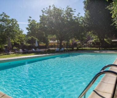 Piscine extérieure dans un parc ombragé au Camping La Ferme de Perdigat