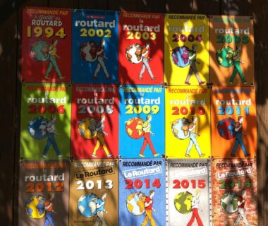 Façade en bois couverte de vignettes Le Routard au Camping La Ferme de Perdigat