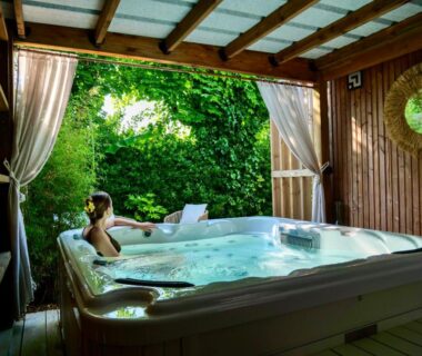 Jacuzzi abrité avec vue sur jardin au Camping La Forêt