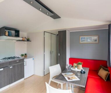 Intérieur avec kitchenette et banquette dans l'hébergement locatif du Camping La Forêt