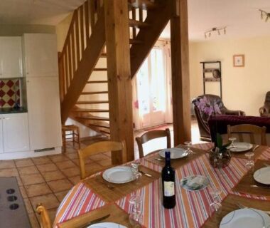 Séjour avec cuisine et table dressée au Camping La Garenne De Moncourt