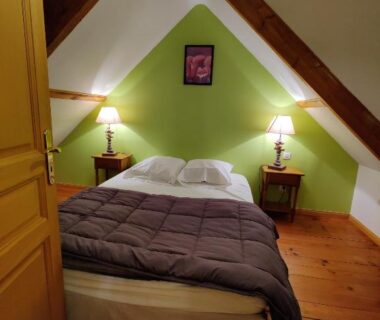 Chambre sous les combles avec lit et poutres apparentes au Camping La Garenne De Moncourt