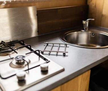 Kitchenette avec plaque de cuisson et évier dans l'hébergement du Camping La Grappe Fleurie