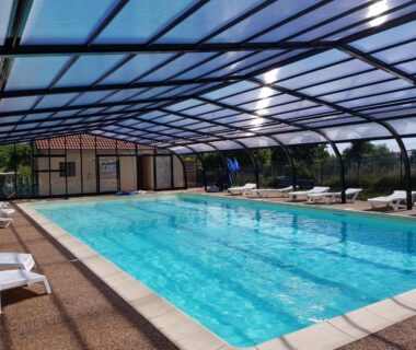Piscine couverte sous abri avec transats au Camping La Grappe Fleurie
