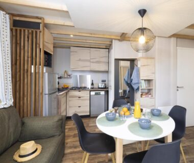 Séjour avec kitchenette et table dressée dans le mobil-home du Camping La Grappe Fleurie