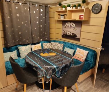 Coin repas intérieur avec banquette et table au Camping La Marine