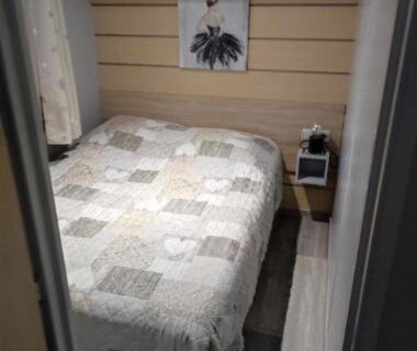 Chambre avec lit double et chevet au Camping La Marine