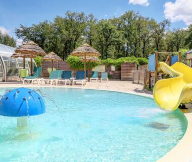 Piscine extérieure avec toboggan jaune et champignon d'eau au Camping La Mignardière