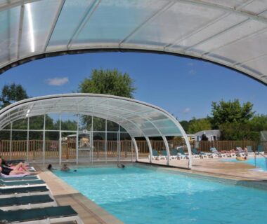 Piscine couverte avec transats dans le Camping La Mignardière