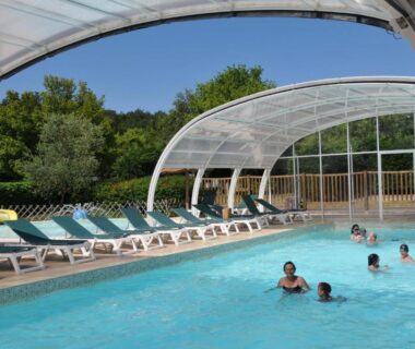 Piscine couverte avec transats au Camping La Mignardière