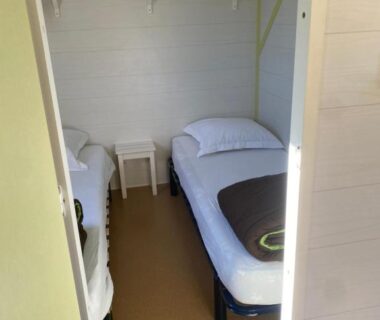 Chambre avec deux lits simples et chevet au Camping La Motte