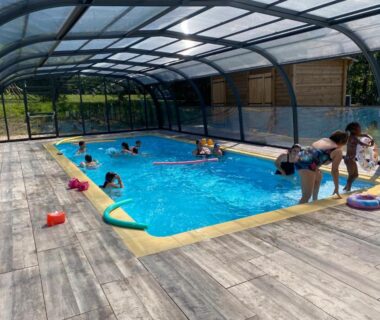 Piscine couverte avec enfants et terrasse au Camping La Motte