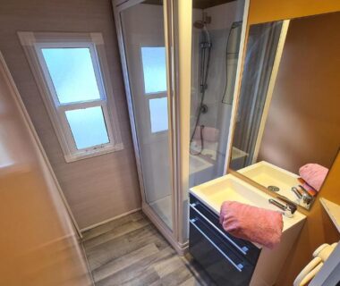Salle de bains avec douche vasque et serviettes roses dans l'hébergement du Camping La Pinatelle