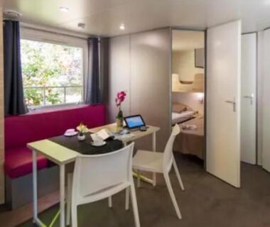 Séjour avec coin repas et lits superposés dans le mobil-home au Camping La Pinatelle