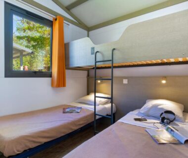 Chambre avec lits superposés et deux lits simples au Camping La Pinède
