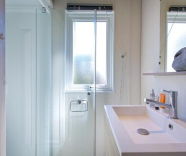Salle de bains avec douche lavabo miroir et fenêtre au Camping La Pinède