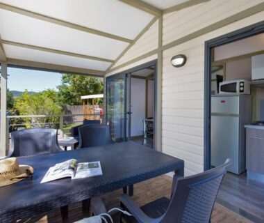 Terrasse couverte avec table et chaises au Camping La Pinède