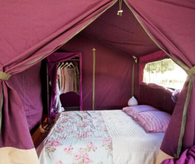 Intérieur de tente en toile violette avec lit double au Camping La Plage