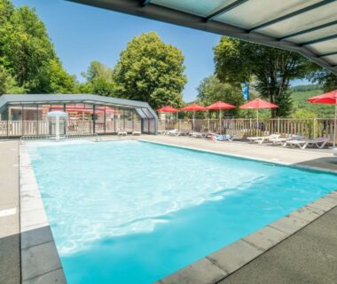 Piscine extérieure partiellement couverte avec parasols au Camping La Plage