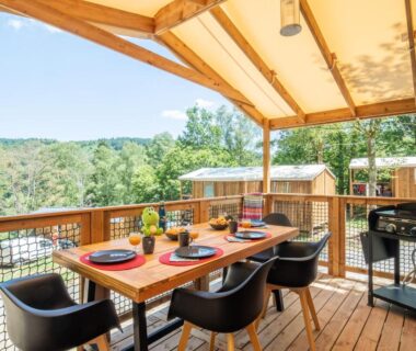 Terrasse couverte avec table dressée et chaises au Camping La Plage