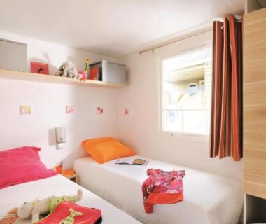 Chambre avec deux lits jumeaux et fenêtre au Camping La Plage