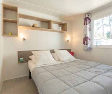 Intérieur chambre avec lit double et fenêtre dans le mobil-home du Camping La Pointe Saint-Gildas Maeva