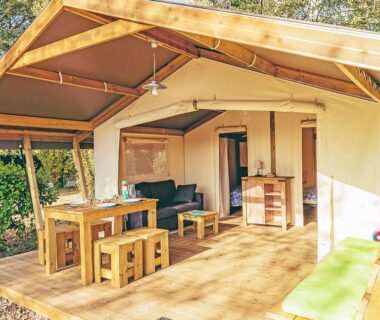 Terrasse couverte avec table et salon en bois du Camping La Pointe du Talud