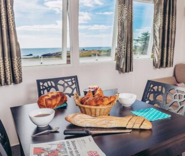 Intérieur avec table dressée et vue mer au Camping La Pointe du Talud