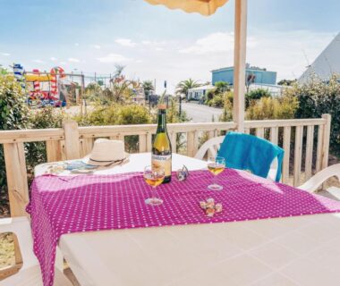 Terrasse avec table bouteille de vin et chaises au Camping La Pointe du Talud