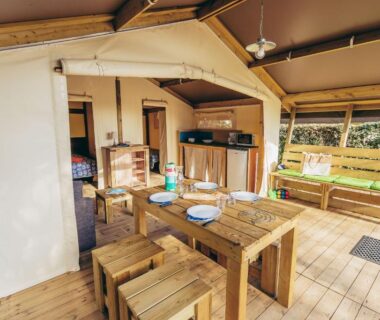 Terrasse couverte avec table et kitchenette du Camping La Pointe du Talud