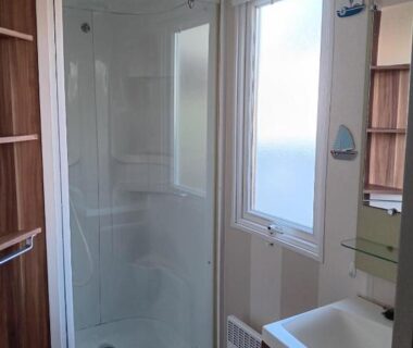 Salle de douche compacte avec fenêtre dans le mobil-home du Camping La Prévoté